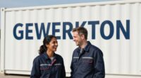 Zwei Fachleute in dunkelblauer Arbeitskleidung lachen vor einem weißen Baucontainer mit dem Schriftzug GEWERKTON